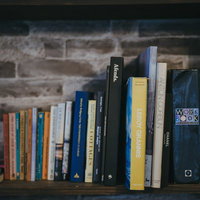 木製の本棚に整然と並んだ洋書の写真の写真