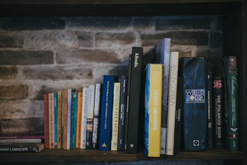 木製の本棚に整然と並んだ洋書の写真