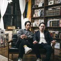 ブリックスタイルの部屋で腰掛けて睨みつける二人組の写真