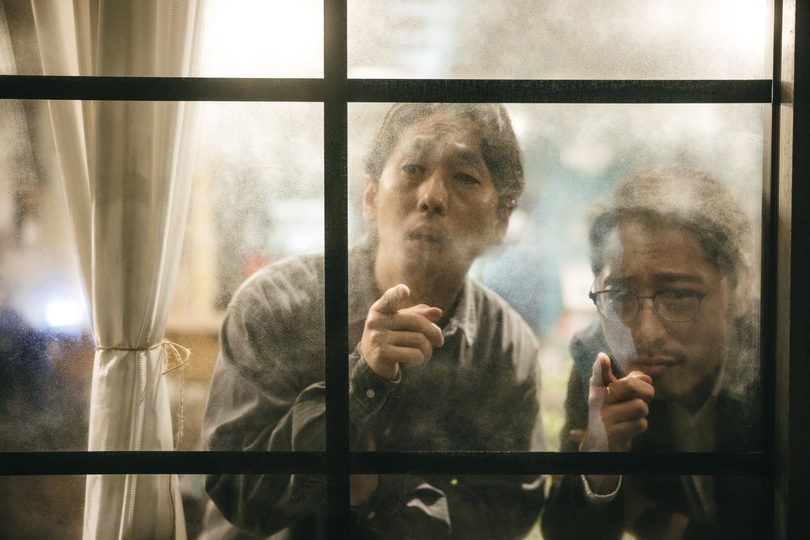 窓の外を見張りながら指を差す二人の男性探偵［モデル：大川竜弥 ゆうせい］