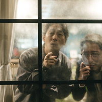 窓越しに対象者を目視する二人の探偵による張り込み調査の写真