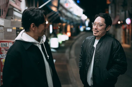 街の喧騒を背に、事件の真相を求めて追跡する二人組の探偵