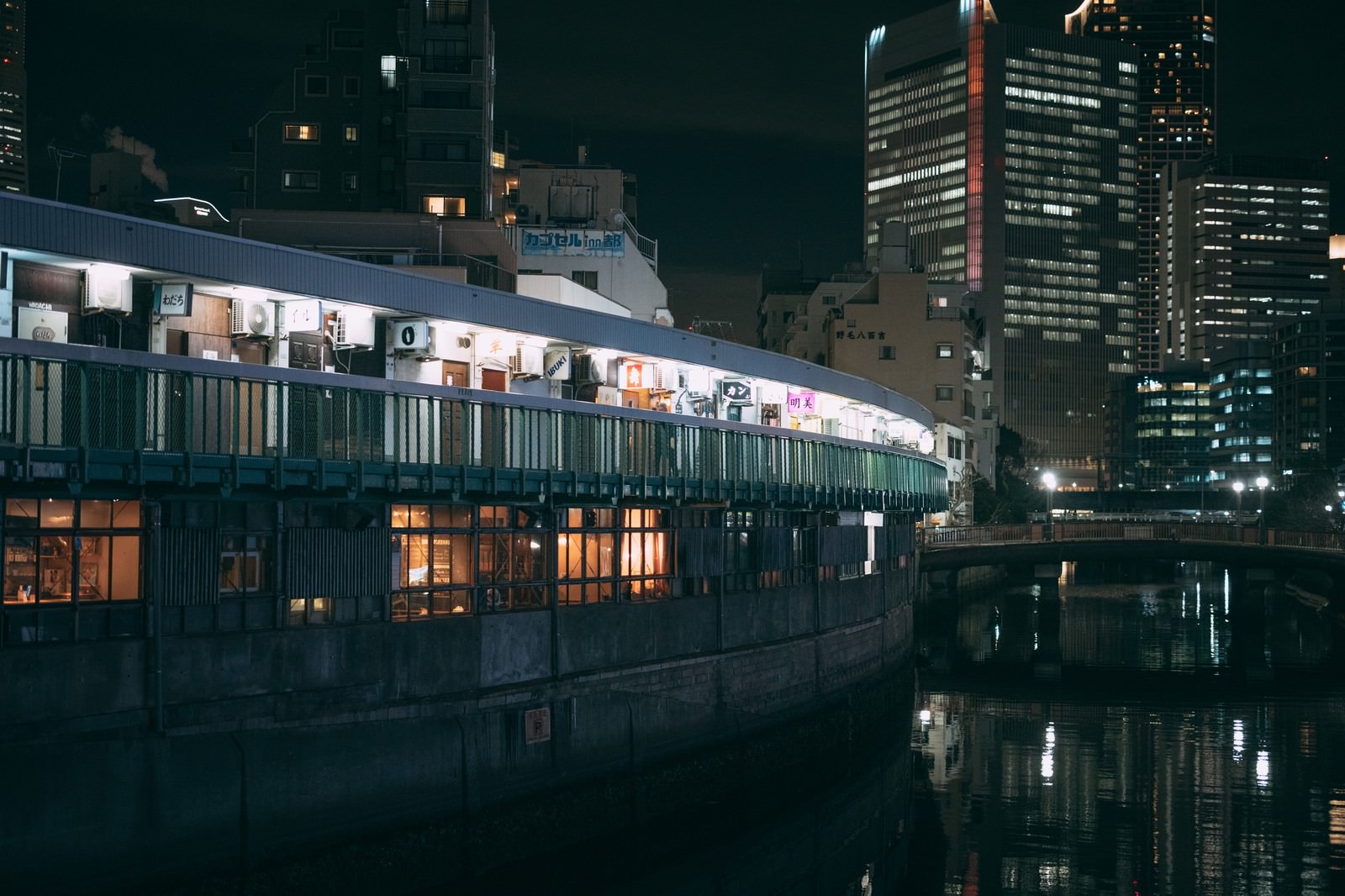夜間に照明が灯る都橋商店街の飲み屋街と大岡川の風景