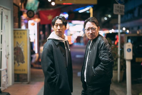 国際通りの商店街をねり歩く男性ふたり、夜間の繁華街を調査