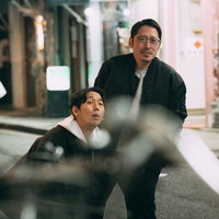 夜の街で調査対象を追跡する探偵ふたりの尾行監視の写真