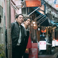 物陰から隠れて身を潜める男性二人による尾行のテクニックの写真