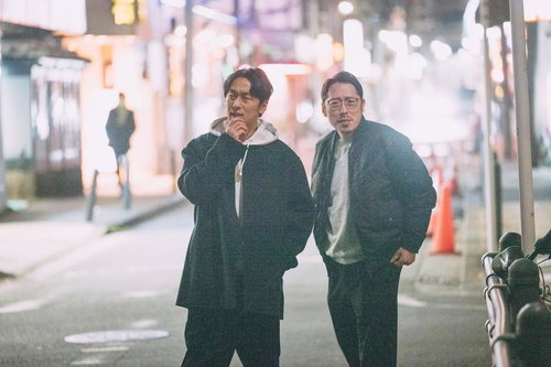 夜の街を徘徊する2人組の男性が立ち話をする深夜の繁華街