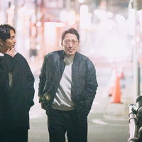 夜の繁華街を歩く二人の男性、尾行調査のシーンの写真