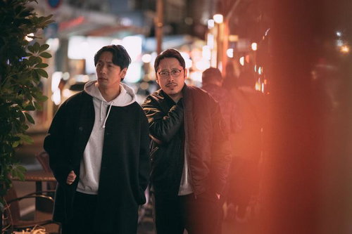 夜の街で尾行する二人の男性の調査・追跡シーン