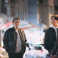 夜の街を歩く男性二人の夜景スナップの写真