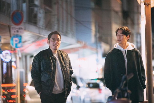 夜の街を歩く男性二人の夜景スナップ