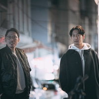 張り込み中に調査対象を見つけた探偵ふたりの写真