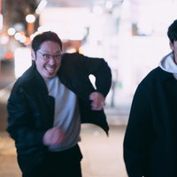 夜の街を走って追跡する眼鏡をかけた男性の全力ダッシュの写真