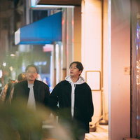 夜の街を散歩しながら会話を楽しむ二人の男性の写真