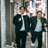 夜の街を走り抜ける二人の探偵の写真