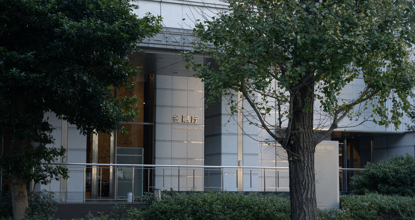 街路樹に囲まれた金融庁ビルの入口部分を写した写真