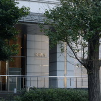 街路樹に囲まれた金融庁ビルの入口と周辺風景の写真