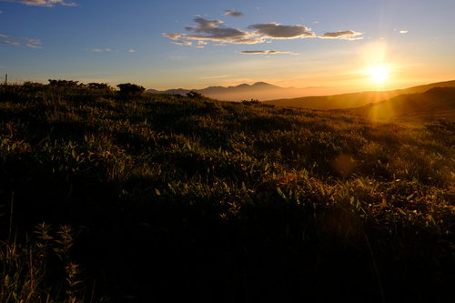 間もなく陽が沈む霧ヶ峰高原の夕景、草原を照らす夕焼け