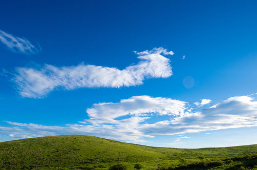 青空と白い雲が広がる霧ヶ峰高原でのハイキング風景