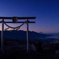 夕暮れ時の霧ヶ峰高原ハイキングコースに立つ鳥居のシルエットの写真