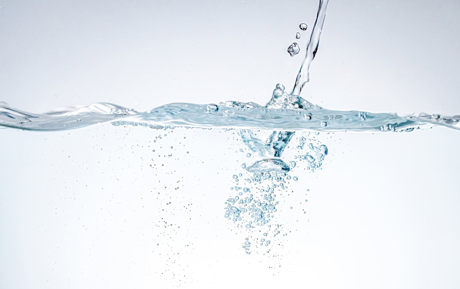 透明な水の中で気泡と水滴が舞い上がる様子