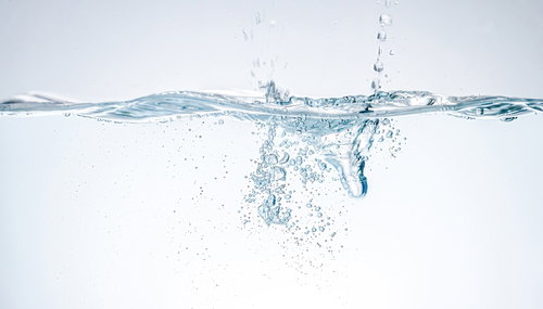 ポチャンと水槽に水が滴る瞬間。透明な水中での水滴落下