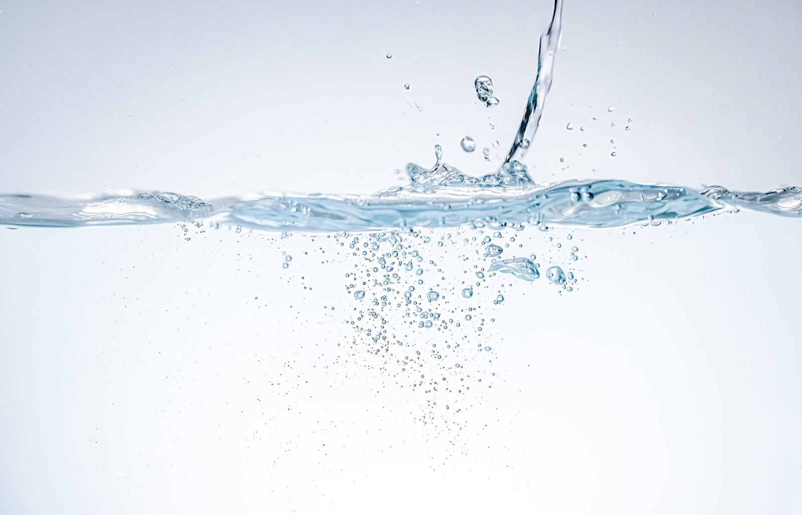 透明な水槽に水が勢いよく注がれ、気泡が舞い散る瞬間