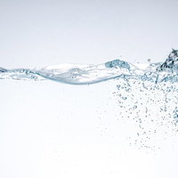 水を注いで水面に波打つ気泡と水流の透明感の写真