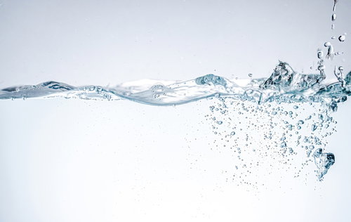 水を注いで水面に波打つ気泡と水流の透明感