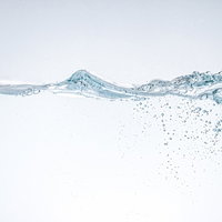 透明な水槽に水を注ぎ入れる瞬間の写真