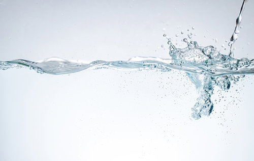 水が注がれて気泡が立ち上る水槽の波紋と液体