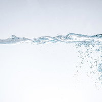 水を注いだ際にできる気泡と水面の波動の流れの写真