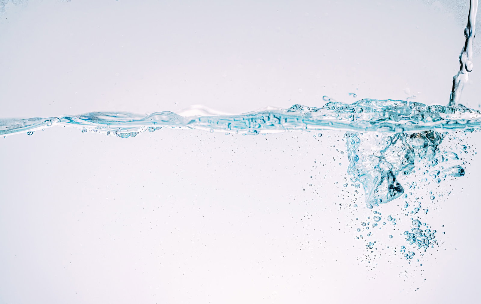 水槽に水が注ぎ込まれ、水面から細かな気泡が広がる様子