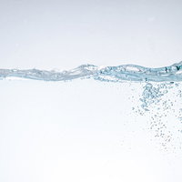 水槽の中で上昇する気泡と水面の波紋の透明な水の流れの写真