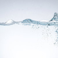 水槽に注ぎ込まれた水と気泡が作る波紋とテクスチャーの写真
