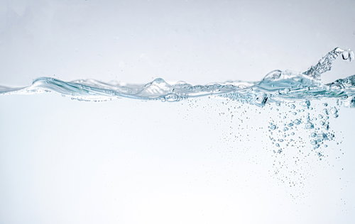 水面の波と気泡が立ち上る水槽の透明な水の流れ