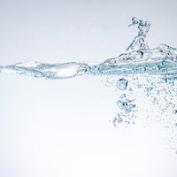 勢いよく注がれた水の気泡が浮遊する透明な液体の写真