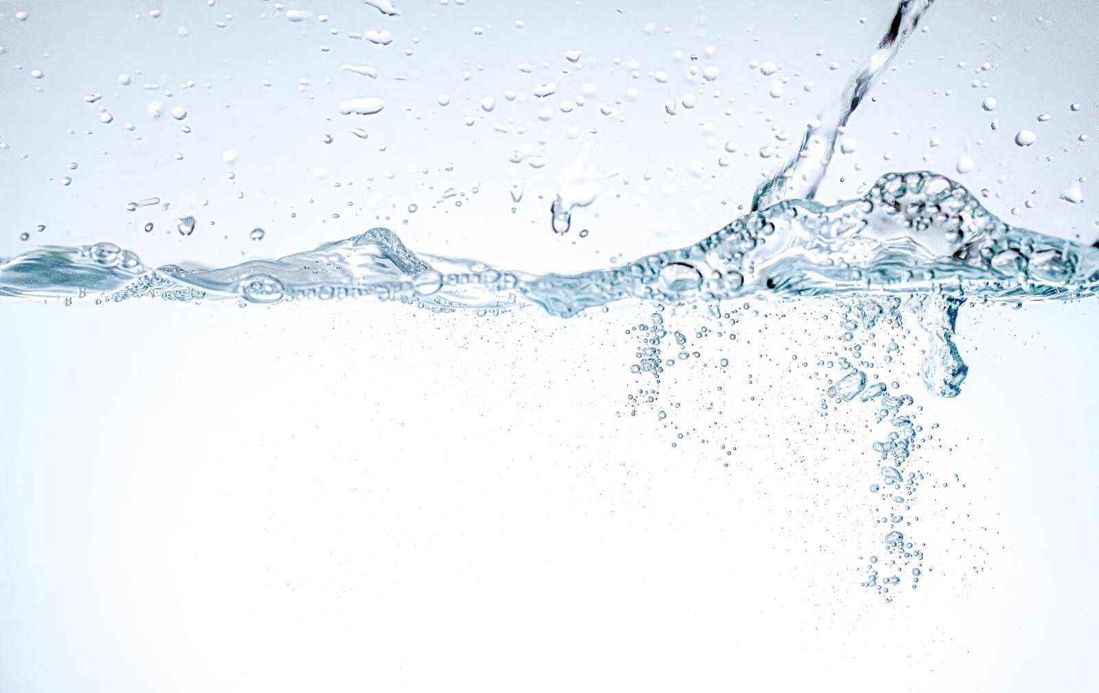 Bubbles floating up and sparkling in the water, with rippling water surface