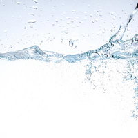 光を受けて輝く水中で舞い上がる気泡と水面の写真