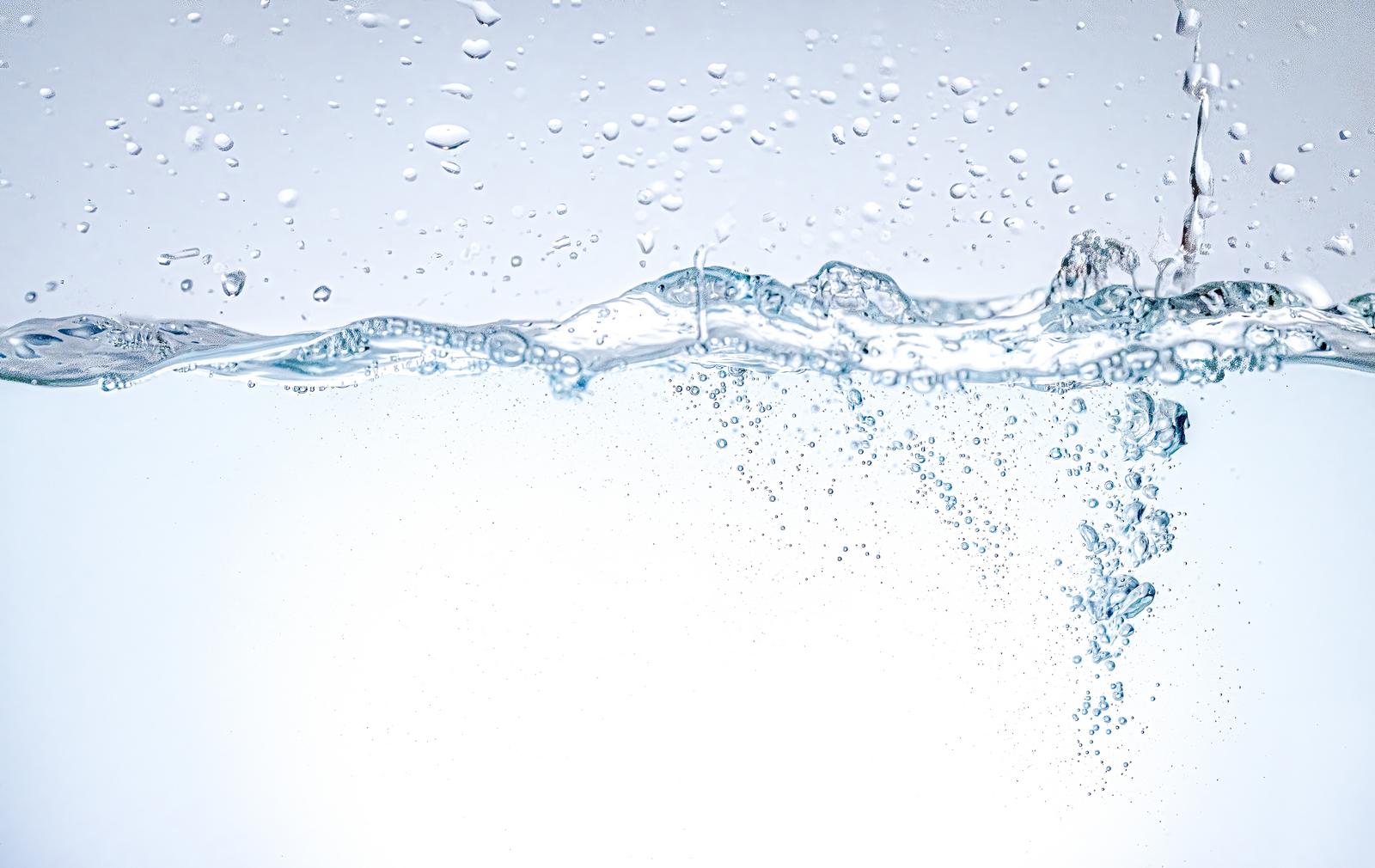 透明な水面に立つ波紋と水中に舞い散る無数の気泡