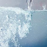 ドバドバお水を注ぐ側面、気泡が立ち昇る透明な水面の写真