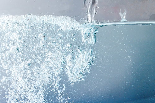 ドバドバお水を注ぐ側面、気泡が立ち昇る透明な水面