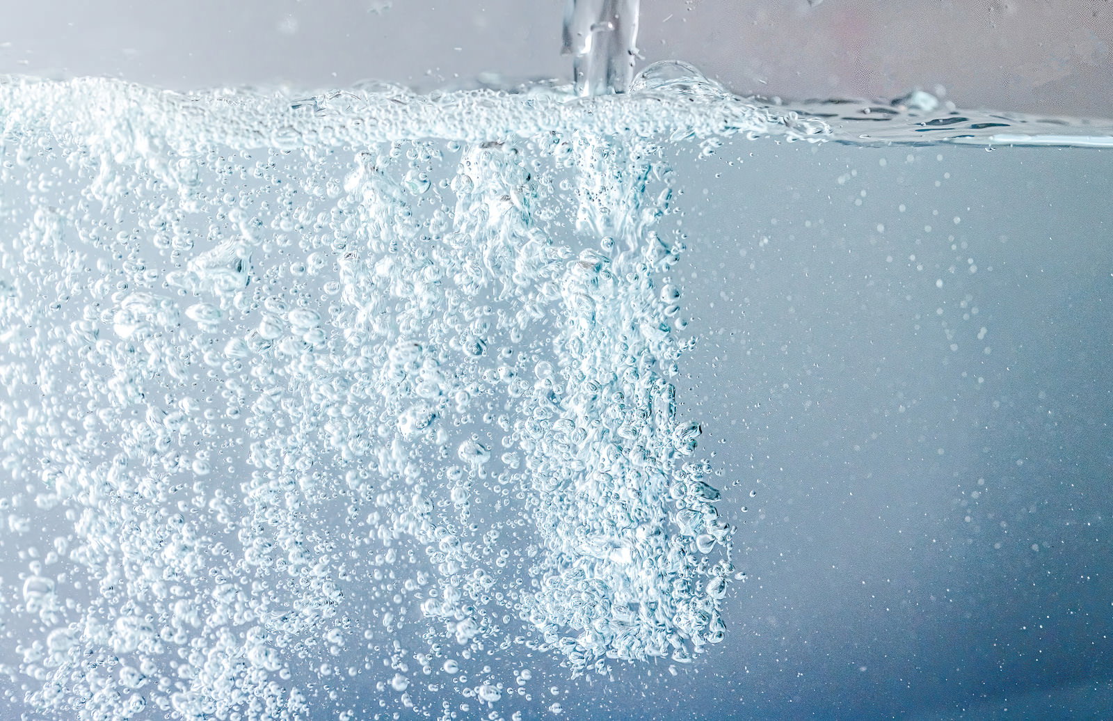透明な水に気泡が立ち上り、細かな泡が光を受けてきらめく様子