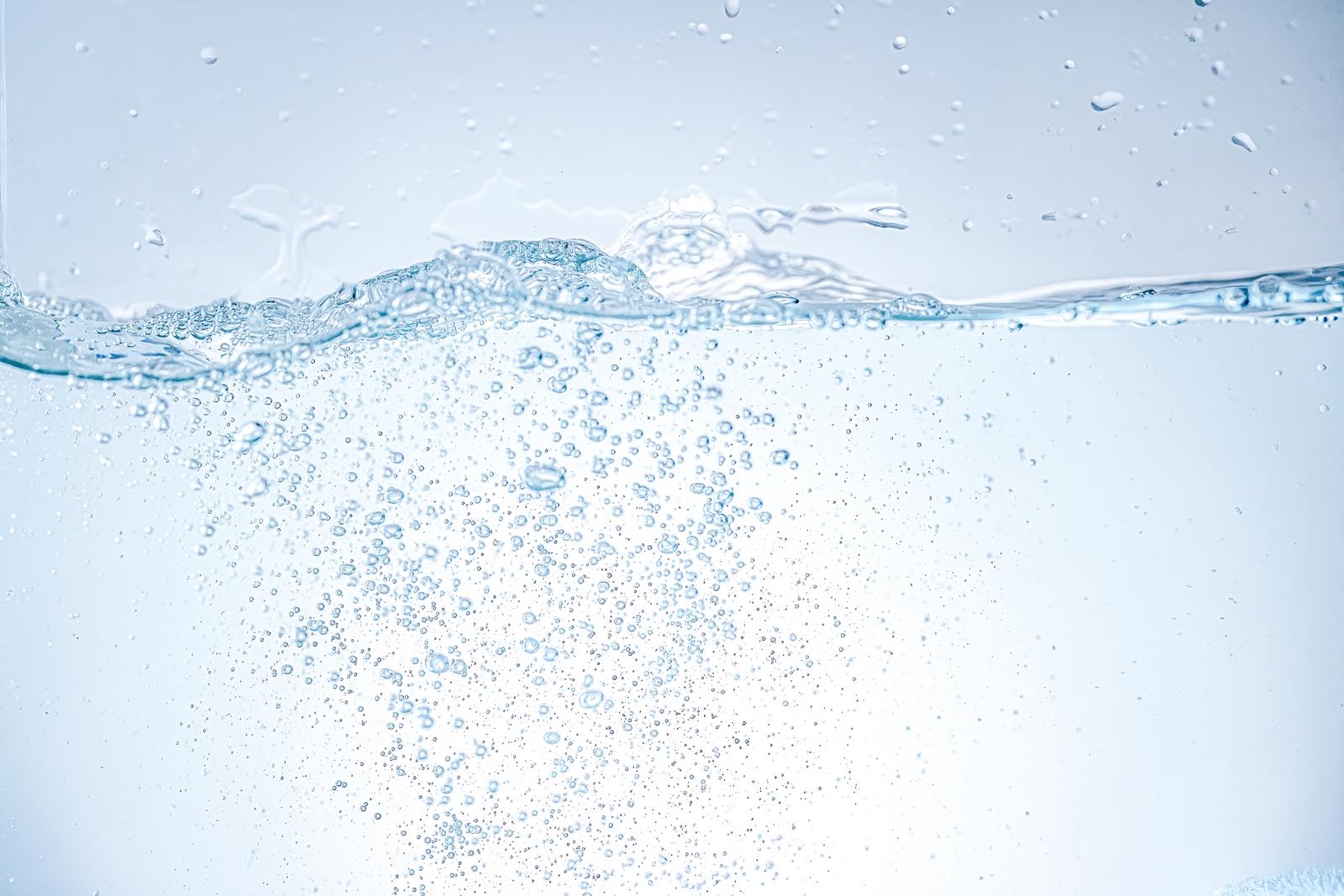 透明な水に無数の気泡が上昇している写真