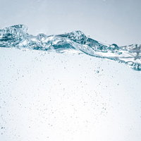 揺れる水面の波と気泡が輝く透明な水槽のの写真