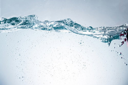 揺れる水面の波と気泡が輝く透明な水槽の