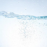 水面で輝く気泡が舞うミネラルウォーターの流れの写真