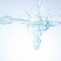 ミネラルウォーターが勢いよく注がれる瞬間の水しぶきの写真