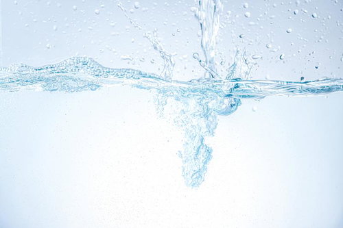 ミネラルウォーターが勢いよく注がれる瞬間の水しぶき