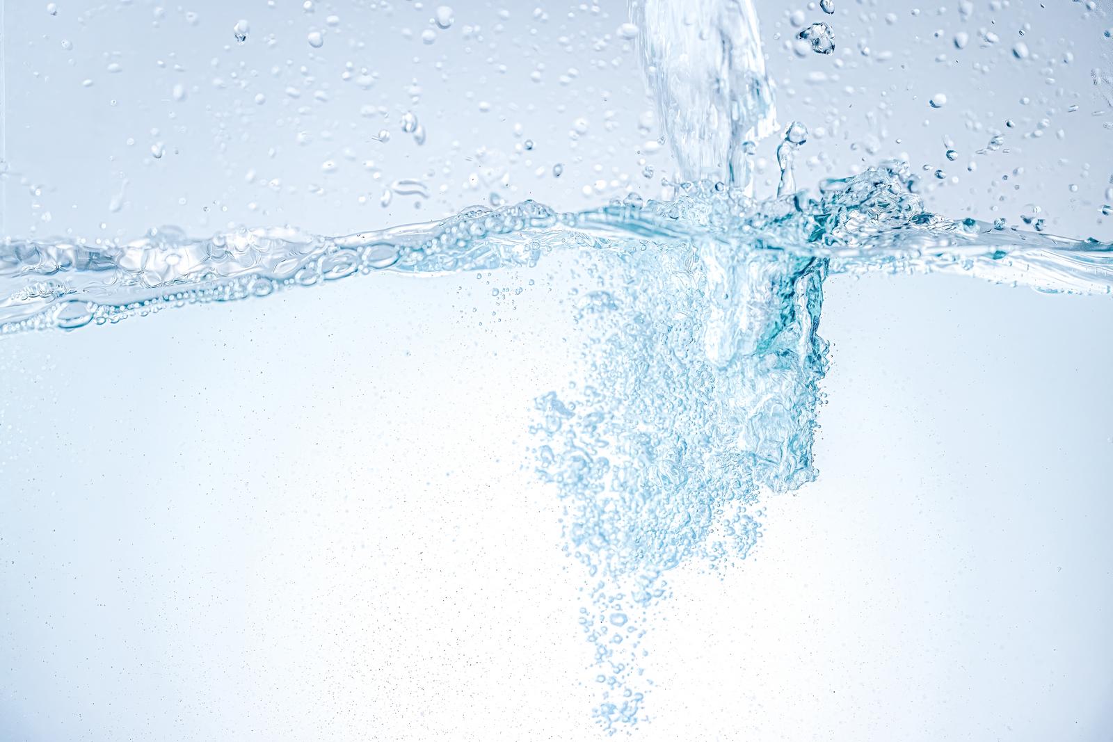 水面に水が注がれ水中に細かな気泡が広がっている様子